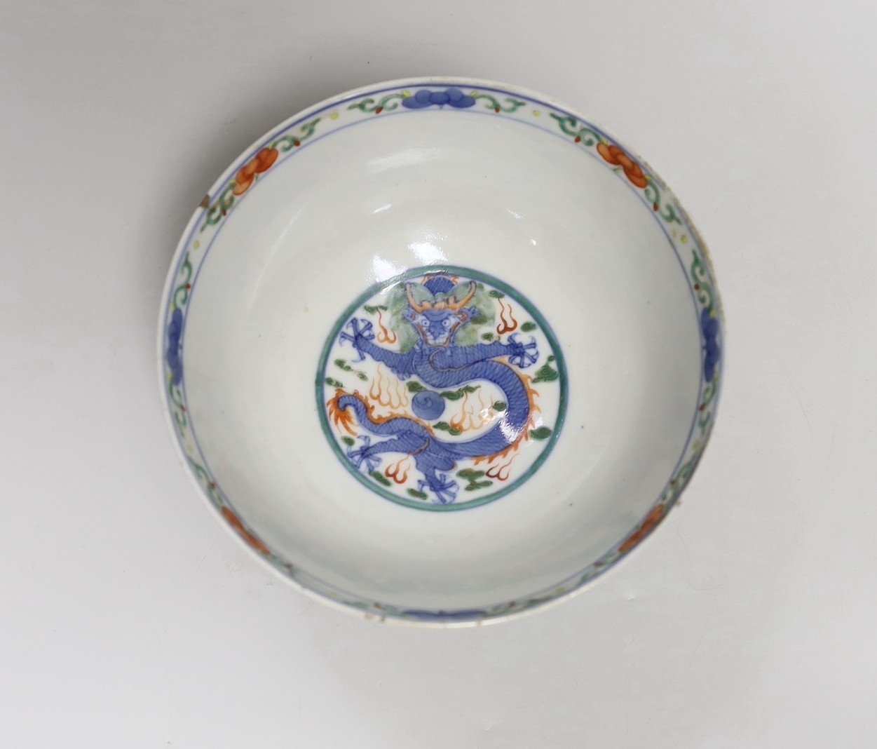 A Chinese wucai ‘boys’ bowl, Kangxi mark late 19th/early 20th century, dragon to the interior, 16.5cm diameter